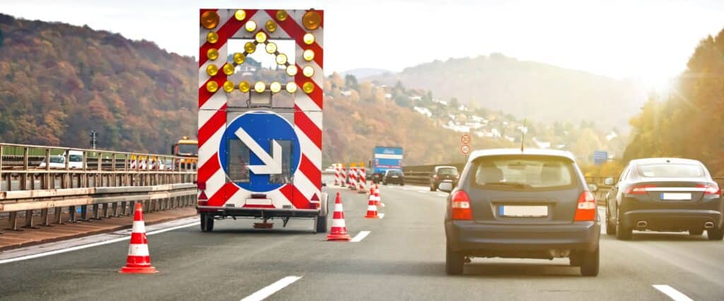 Autos auf der Autobahn in der Schweiz beim Reissverschlussverkehr an einer Baustelle mit Spurabbau - Hero Desktop